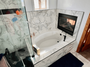 Luxury marble bathroom with soaking tub, fireplace, and glass shower — elegant Utah bathroom remodel