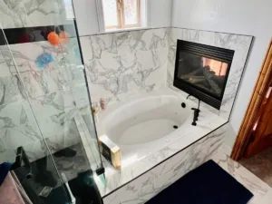Luxury marble bathroom with soaking tub, fireplace, and glass shower — elegant Utah bathroom remodel