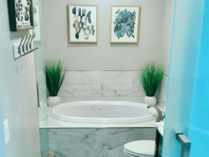 Modern bathroom remodel featuring a marble bathtub, minimalist decor, and greenery for a spa-like atmosphere.