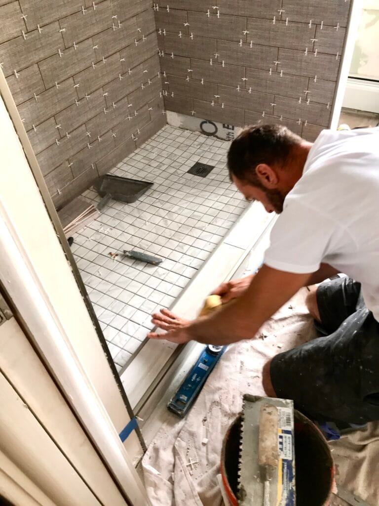 Bathroom tile installation in progress — professional shower base leveling and wall tiling during custom bathroom remodeling in Utah.