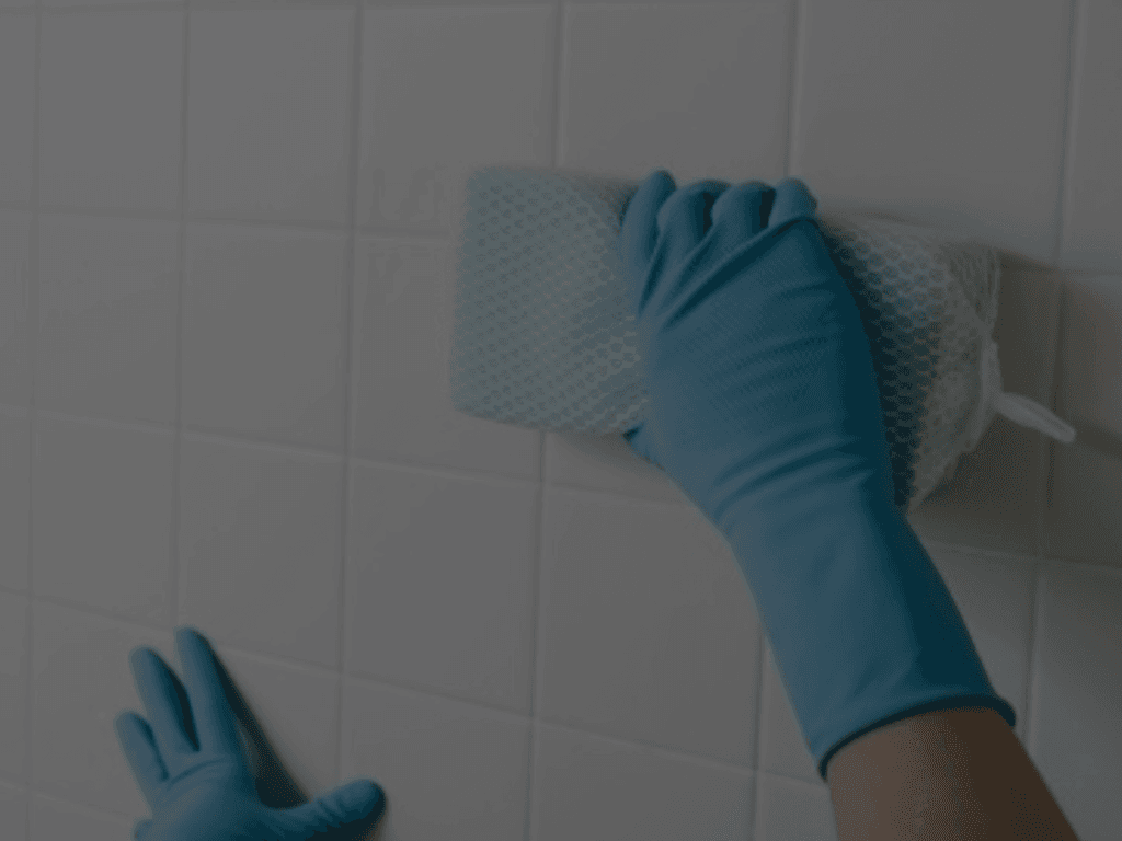 Cleaning ceramic tiles with a sponge for spotless kitchen, bathroom, or patio surfaces.